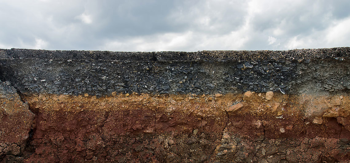 A layer of dirt with the a cloudy sky above