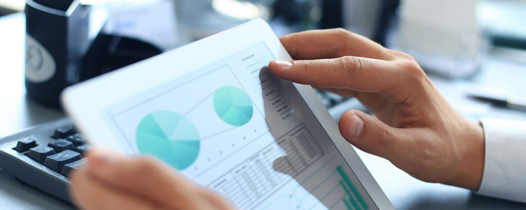 A person analyzing graphs displayed on a tablet, focused on data interpretation and insights.