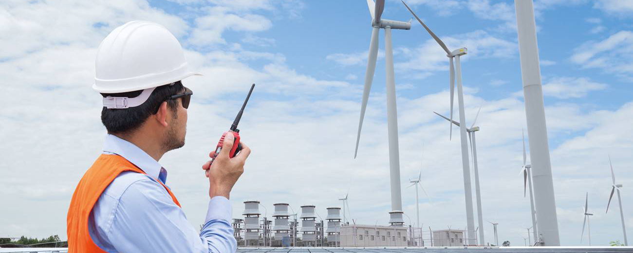 Man watching a power plant with wind turbines